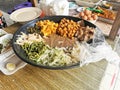 Gado-gado ingredients containing boiled vegetables, boiled eggs, fried tofu and tempeh, chips, served with peanut cashew sauce.