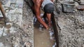 Selective focus image, workers clearing sewers from clogged trash