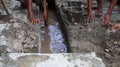 Selective focus image, workers clearing sewers from clogged trash