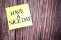 Selective focus image of yellow sticky note with HAVE A NICE DAY wording on a wooden background. Life concept Royalty Free Stock Photo