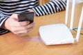 Selective focus at internet router with man using smart phone device to connect to internet or wireless connection at home, High s