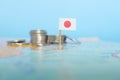 Selective focus of Japanese flag in blurry world map with coins. Japan economy and wealth concept. Royalty Free Stock Photo