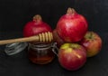 Honey, pomegranate, and apples on the black table. Jewish New Year Rosh Hashanah postcard