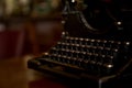 Selective focus on the keyboard key on an old black rustic typewriter on a desk in the office. The typewriter is a lot old so the