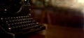 Selective focus on the keyboard key on an old black rustic typewriter on a desk in the office. The typewriter is a lot old so the