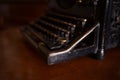 Selective focus on the keyboard key on an old black rustic typewriter on a desk in the office. The typewriter is much used but is