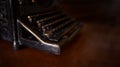 Selective focus on the keyboard key on an old black rustic typewriter on a desk in the office. The typewriter is much used but is