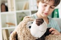 Focus of kid with dyslexia holding teddy bear