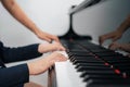 Selective focus on the kid finger playing grand piano. Teacher or instructor teach a boy on the class play melody. Close up hand Royalty Free Stock Photo