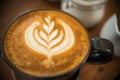 Selective focus of latte art foam pattern on top of cappuccino coffee cup for coffee break time Royalty Free Stock Photo