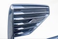 Selective focus on left side of front bumper decorative element parking sensor of luxurious car bumper closeup with grid