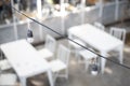 Selective focus of light bulb with wire on blurry table and chair background in cafe Royalty Free Stock Photo