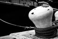 Selective focus on line securing a naval boat to a port bollard.