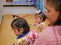 Selective focus of little Asian baby girl  furthest  looking and standing in a shopping cart with her sister Royalty Free Stock Photo