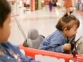 Little Asian baby girl, 17 months old, right biting a steering wheel of a mini car - toddlers and biting Royalty Free Stock Photo