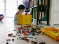 Selective focus of a little Asian baby girl searching a box of toys and spreding them all over the floor Royalty Free Stock Photo