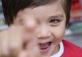 Selective focus little boy with smiling face pointing finger at camera, Candid short of kid primary school boy pointing at you