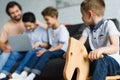 selective focus of little boy on wooden horse toy and family using laptop together on sofa Royalty Free Stock Photo