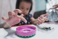 Selective focus. The little girl`s hand is touching the white glue in the pink plastic cap. Royalty Free Stock Photo