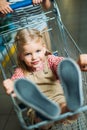 selective focus of little girl sitting in shopping cart