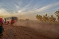 Selective focus Local Bus driving fast with dust cloud on road to Bidar