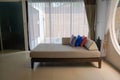 selective focus long fabric sofa bed with pillow in large living room in hotel villa for honeymoon