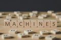 Focus of machines lettering on cubes surrounded by blocks with letters on wooden surface isolated on black