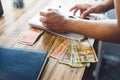 Selective focus of male hands writing and at the same time calculating Honduran lempiras Royalty Free Stock Photo