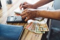 Selective focus of male hands writing and at the same time calculating Honduran lempiras Royalty Free Stock Photo