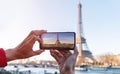 Man hand with he is using smartphone take photo at View on Eiffel Tower, Paris, France Royalty Free Stock Photo