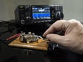 Selective focus of man& x27;s hand on a telegraph key with radio defocused in background Royalty Free Stock Photo