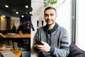 Selective focus on man`s hands holding modern digital smartphone device and chatting in social networks. Blurred young man sendin Royalty Free Stock Photo