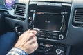 Selective focus of  man using car audio stereo system while driving his car. Royalty Free Stock Photo