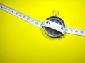 Selective focus.Measuring tape and compass on a yellow background.Shot were noise and film grain. Royalty Free Stock Photo