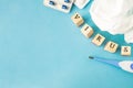 Selective focus on medical pills, used tissue and thermometer on blue background, copy space