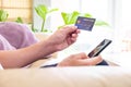 Selective focus at men hand holding credit card while type payment information into smartphone. Online purchase transaction during Royalty Free Stock Photo