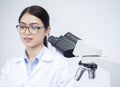 Selective focus of microscope with young Asian woman working in lab blur behide Royalty Free Stock Photo