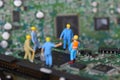 Selective focus of miniature engineer and worker meeting to fixed problem chipset of Personal computer PC on blurred mainboard Royalty Free Stock Photo