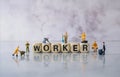 Selective focus of miniature engineer and worker team work building word