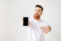 Selective focus. Modern smart phone with blank screen in man s hands. Bearded stylish man advertizes mobile phone in