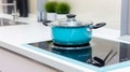 modern white and turquoise kitchen interior with pot on electric induction cook top. generative ai