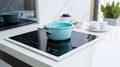 modern white and turquoise kitchen interior with pot on electric induction cook top. generative ai