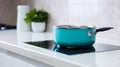 modern white and turquoise kitchen interior with pot on electric induction cook top. generative ai