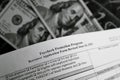 Selective focus monochrome photo of paycheck protection program borrower application form revised, on a background of dollar bills Royalty Free Stock Photo