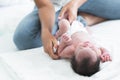 Selective focus on mother finger of Asian Australian newborn baby sleeping while her mom is changing diapers and clothes little