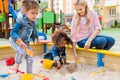 selective focus of mother playing with daughter and her little friend in sandbox Royalty Free Stock Photo