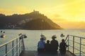 Happy family sitting on staire and watching the sunset in San Sebastian, Spain