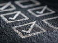 Selective focus on multiple hand-drawn checkmarks inside square boxes on textured dark chalkboard symbolizing task completion and Royalty Free Stock Photo