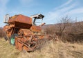 Selective focus on old abandoned combine harvester for grain crops in the field. Broken rusty equipment