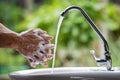 Selective focus of the old man hand image washing with dishwashing liquid and clean water on the sinks in the house near garden